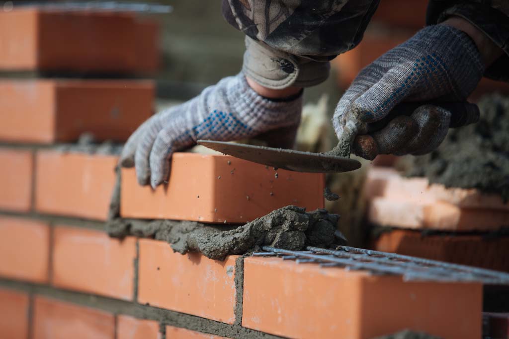 Brick wall contruction with mason hands