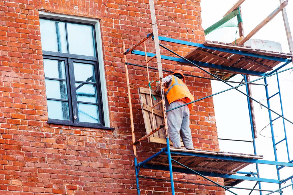 Restoration of the facade of an old building. The builder sets scaffolding for repair work. Close-up